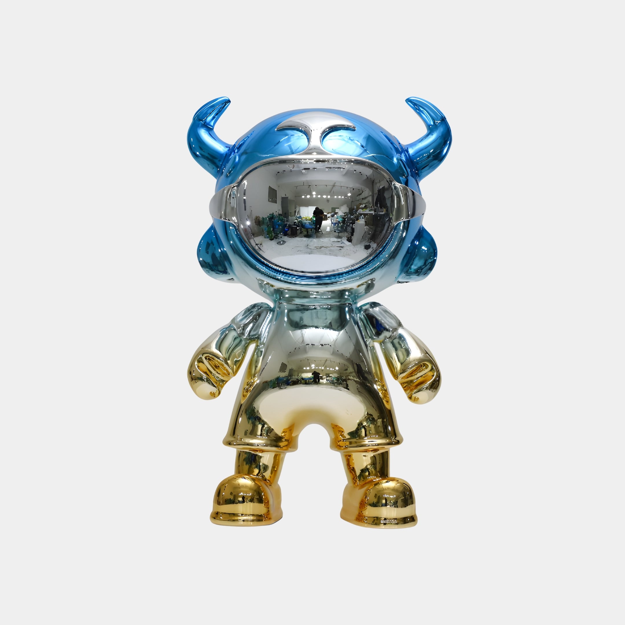 The Giant Sculptures Blue & Gold Astro Devil Figure - 80cm features a mirror-finish metallic astronaut with blue horns, a blue helmet, and a reflective visor in silver, gold, and blue tones on a plain white background.