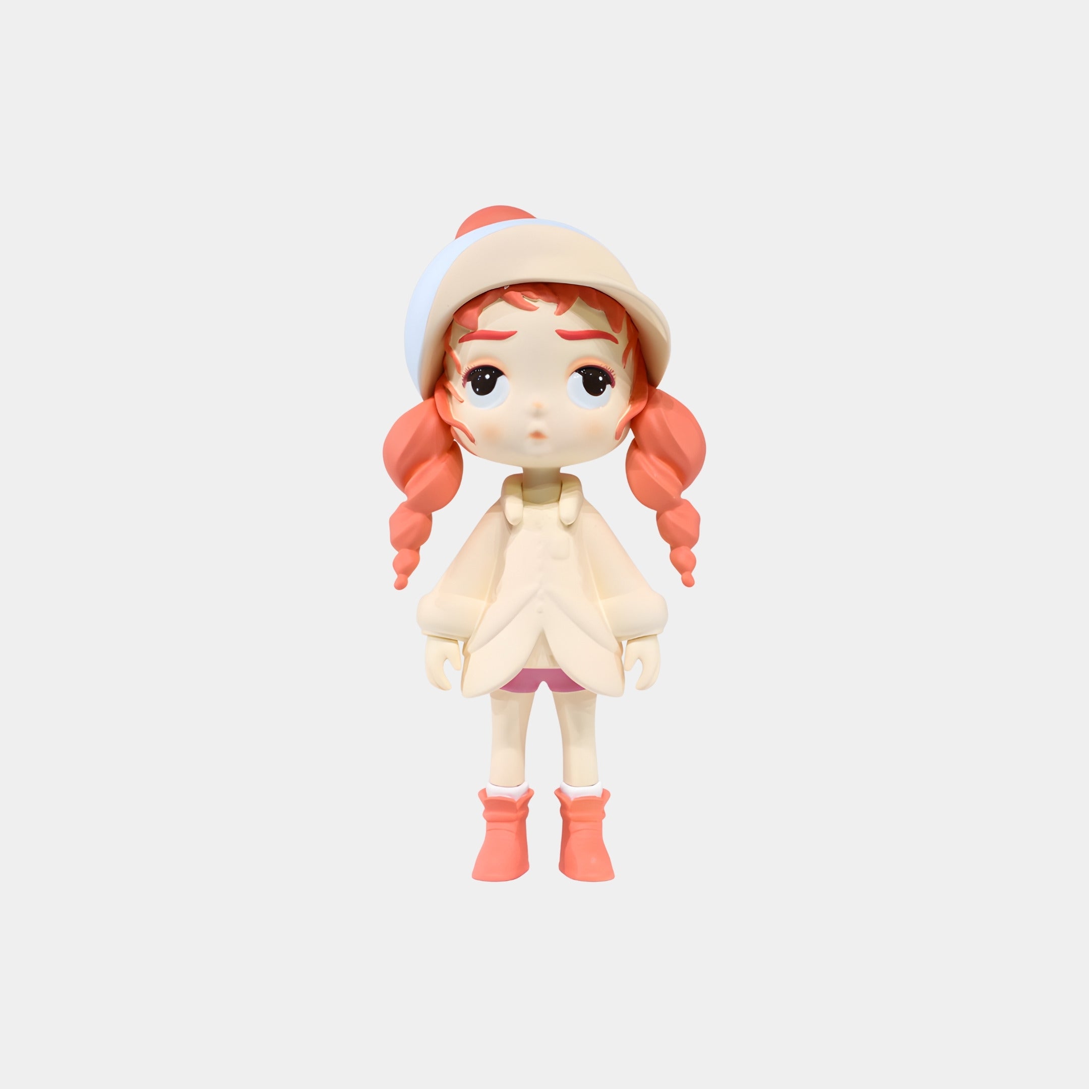 The Soft Coral & Cream Winter Girl Figure by Giant Sculptures is a 25cm hand-painted collectible featuring a light-skinned girl with pinkish-red braids, in a cream hat and jacket, pink skirt, and boots, shown on a white background.