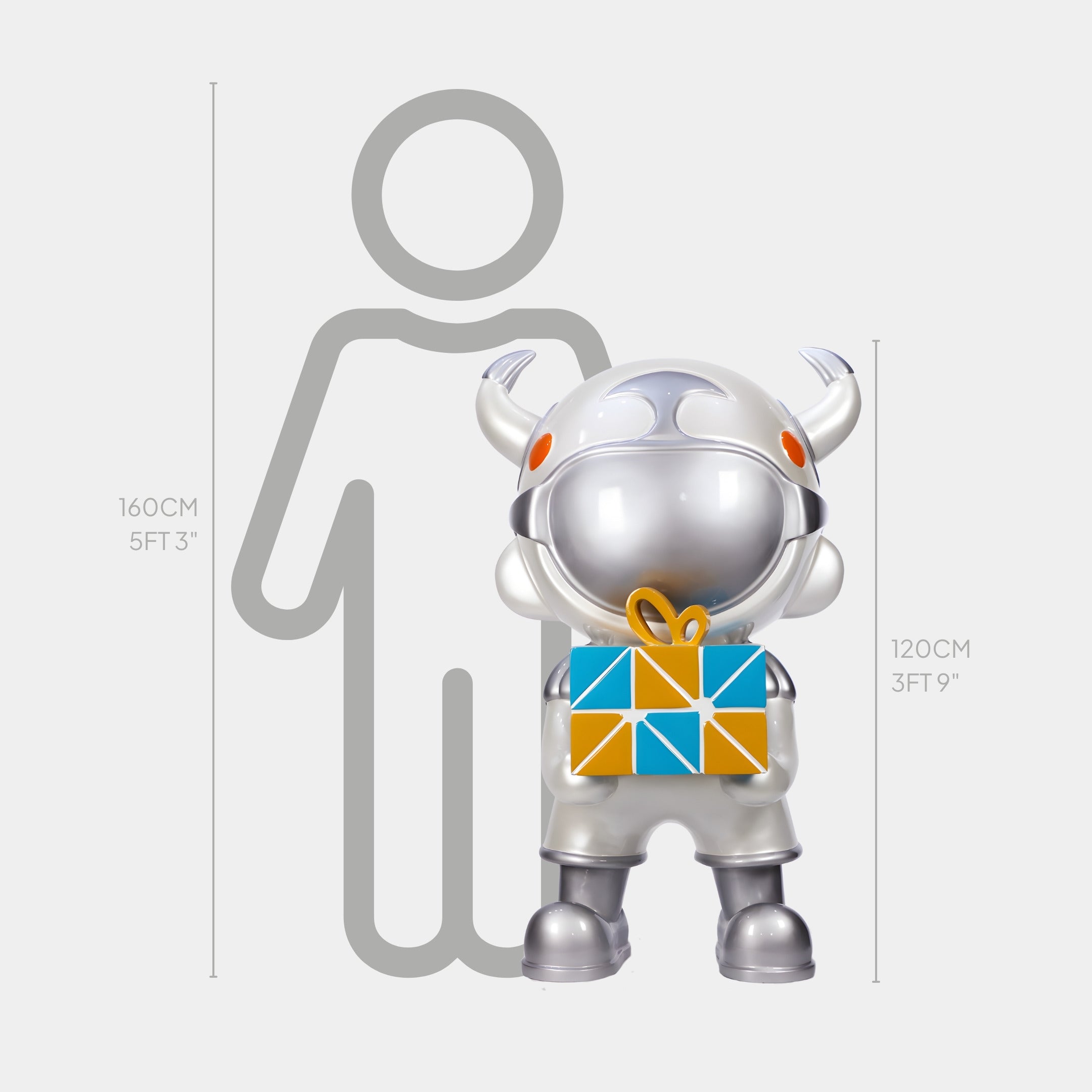 The Titan Silver Gift Box Astro Devil Sculpture by Giant Sculptures stands 120 cm tall, depicting a silver astronaut holding a colorful gift in front of a height chart beside a 160 cm person outline.