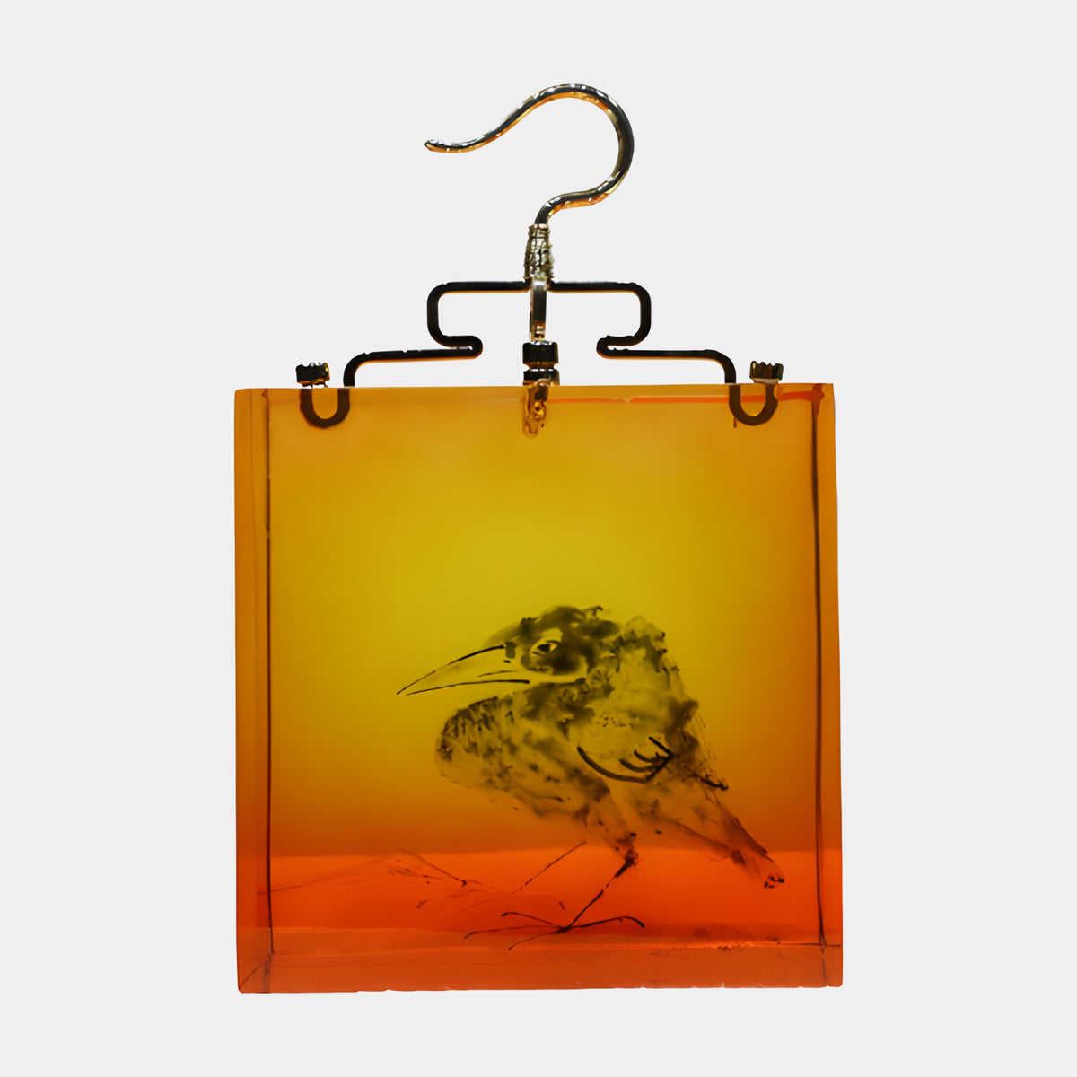 Ink Bird in Amber Resin Hanging Sculpture - 37cm, a square amber resin block shading from gold to orange with an ink-brushed bird, held by a bronze carrier and gilded hook against a plain white background.