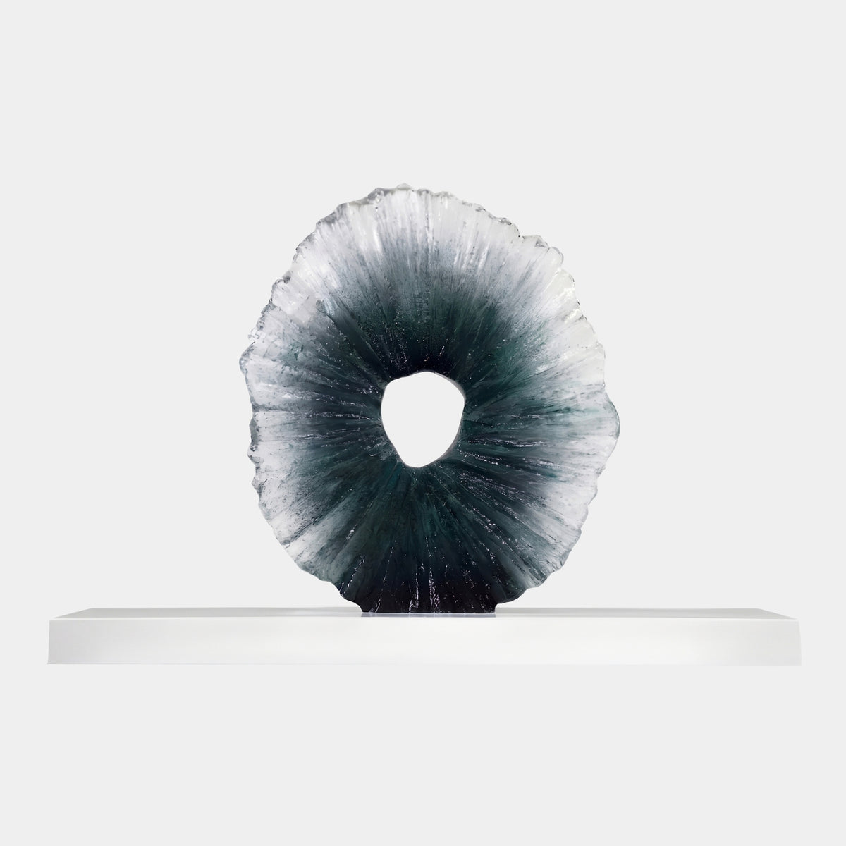 Green to Clear Radiating Disc Resin Sculpture, 100cm, with ribbed texture lightening from green core to clear rim, on a long white marble base against a plain light background.