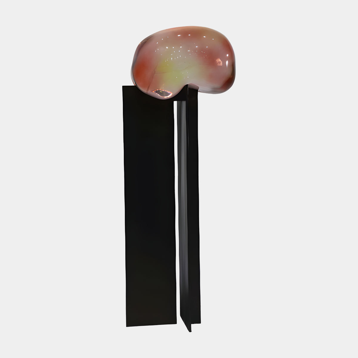 Opalescent Pebble on Metal Plates Sculpture - 151cm, a smooth pink-and-green glossy pebble form resting on two upright black metal plates, shown against a plain light grey background.