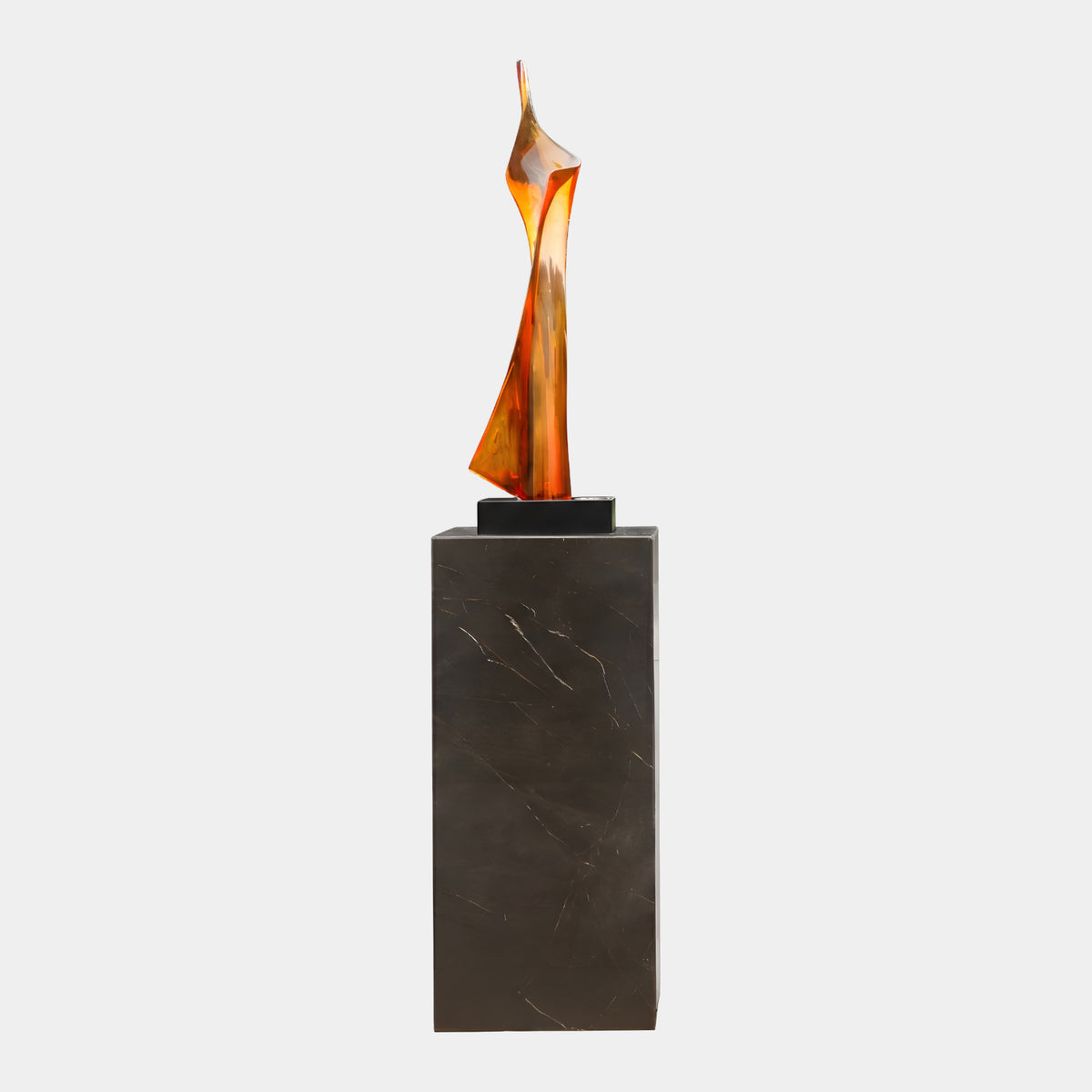Amber & Red-Brown Furled Flame Resin Sculpture (180cm) by Giant Sculptures, a twisting flame-like form on a black block atop a tall marble plinth, set against a plain light background.