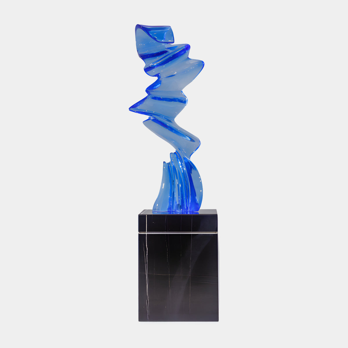 Blue Folded Zigzag Band Resin Sculpture, 150cm, on a black marble plinth, set against a plain light grey background.