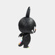 A side view of The Monster Zimomo Titan Labubu Sculpture by Giant Sculptures—70cm, black and furry with one large ear, white eyes, sharp teeth, and colorful spikes—makes a striking interior decor piece against a plain white background.