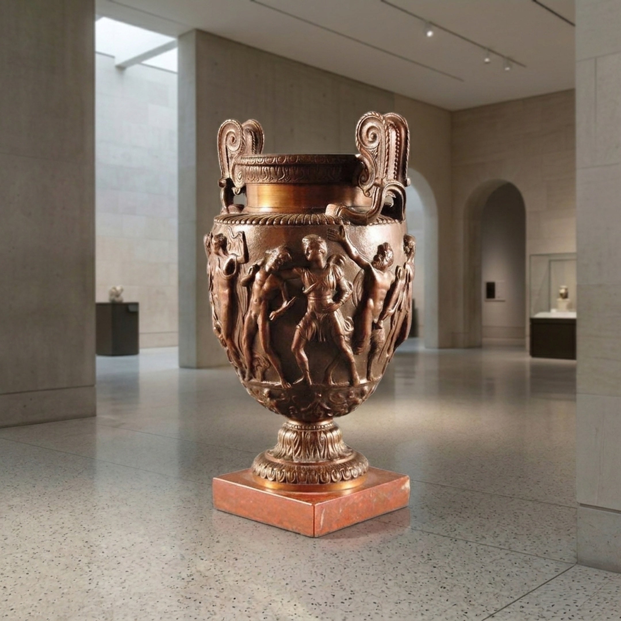 Giant Sculptures Classical Bronze Urn Vase with Figural Frieze, 100cm, on a red marble plinth in a neutral gallery space with archways.