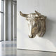 Classical Bull Head Bronze Relief by Giant Sculptures in satin gold, mounted on a white wall in a minimalist concrete interior with floor-to-ceiling windows.