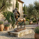 Classical Centaur and Nude Female Figure Bronze Sculpture by Giant Sculptures with brown patina on a stone plinth in a Mediterranean courtyard with olive trees and lavender.