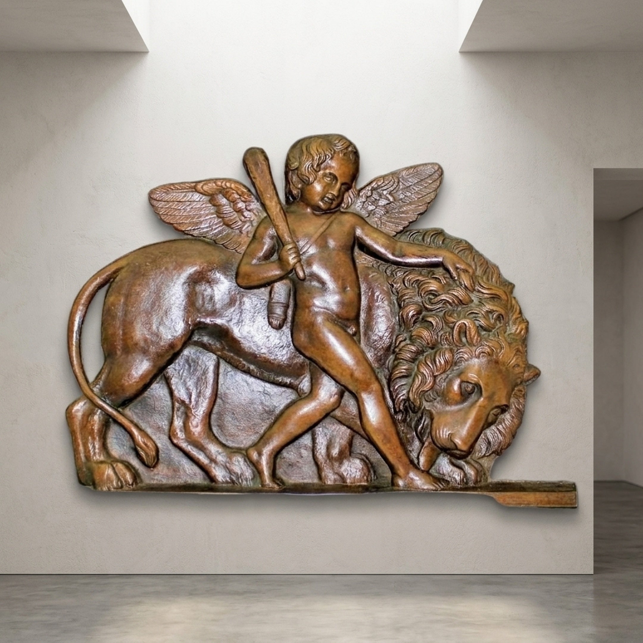 Giant Sculptures Classical Cherub Subduing a Lion Bronze Relief, 70cm, winged putto with club pressing a lion's back, warm brown patina, mounted on a pale wall.