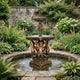 Giant Sculptures 230cm Classical Four Cherub Bronze Fountain with tiered fluted basins and putto figures, set in a circular pond within a walled garden.
