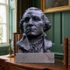 Classical Historical Male Bust Bronze Bust 90cm by Giant Sculptures on a granite plinth, displayed on a wooden desk among leather books in a green-panelled library.