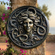 Classical Medusa Head Bronze Relief 80cm by Giant Sculptures, mounted on a stone column with serpents and foliage framing the face, overlooking the sea.