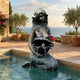 Classical Seated Mermaid Bronze Fountain by Giant Sculptures, 100cm, with antique patina, beside a tiled pool overlooking olive trees and the sea.