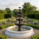 Classical Tiered Bird Fountain by Giant Sculptures, 250cm bronze five-tier fountain with perched birds and white marble pool in a formal lavender garden.