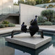 Giant Sculptures Contemporary Abstract Rotund Figures Bronze Sculpture in near-black patina, two biomorphic figures on a bench, set on a concrete plinth above a pool.