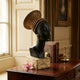 Giant Sculptures Contemporary African Female Bust Bronze Sculpture 70cm with matte black face and coiled gold headwrap, displayed on a wooden console beside antique books.