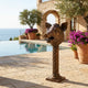 Giant Sculptures Contemporary Boar Head Bronze Sculpture on a twisted column beside a poolside terrace with terracotta planters, olive tree, and sea view.
