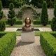 Giant Sculptures Contemporary Hooded Anonymous Bust in bronze with polished gold mask and Bitcoin medallion, on a pale marble plinth in a hedged garden.