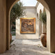 Contemporary Horse Head Bronze Relief 100cm by Giant Sculptures, oak-framed panel mounted on a cream wall in a sunlit Mediterranean courtyard with olive trees.