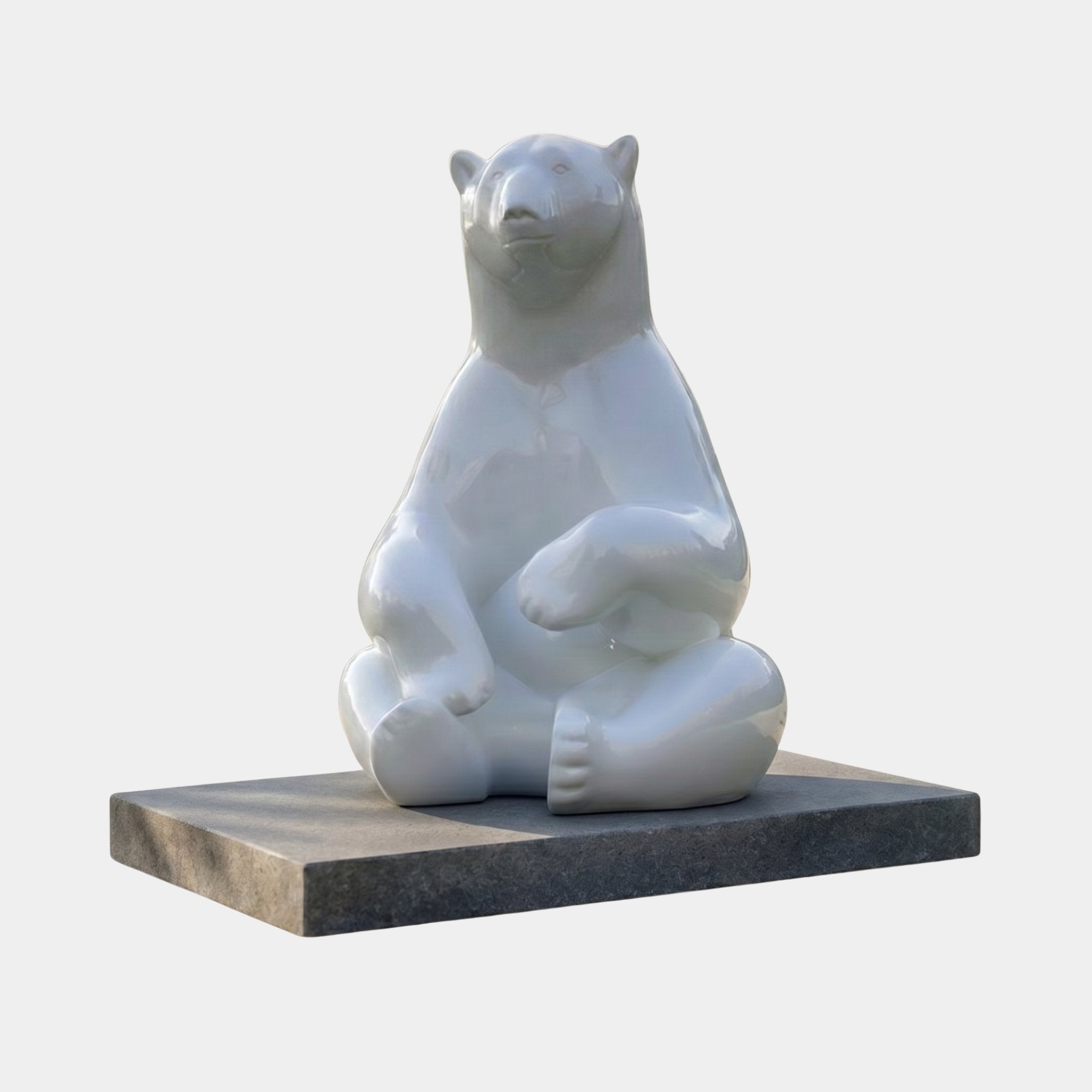 Giant Contemporary Polar Bear Bronze Sculpture by Giant Sculptures, seated upright with crossed legs, high-gloss white finish on a black rectangular plinth.