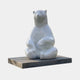 Giant Contemporary Polar Bear Bronze Sculpture by Giant Sculptures, seated upright with crossed legs, high-gloss white finish on a black rectangular plinth.