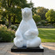 Giant Sculptures Giant Contemporary Polar Bear Bronze Sculpture 240cm in high-gloss white, seated with paws forward on a black plinth in a sunlit garden.