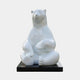 Giant Contemporary Polar Bear Bronze Sculpture by Giant Sculptures, seated upright with crossed legs and a high-gloss white finish, on a black rectangular plinth.