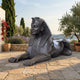 Large Classical Recumbent Egyptian Sphinx Bronze Sculpture by Giant Sculptures shown on a stone terrace with cypress trees and a coastal view behind.