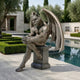 Large Classical Seated Gargoyle Demon Bronze Sculpture by Giant Sculptures, 150cm winged figure on a plinth beside a reflecting pool and clipped hedges.