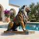 Large Classical Seated Lion Bronze Sculpture by Giant Sculptures in profile on a low plinth beside a villa pool, with bougainvillea and olive trees nearby.