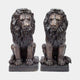 Large Classical Seated Lion Pair Bronze Sculpture by Giant Sculptures, two upright lions with flowing manes and dark patina on plinths, plain background.