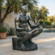 Giant Sculptures Large Classical Seated Male Figure Bronze Sculpture 170cm with dark patina, seated cross-legged on a poolside patio near olive trees and lavender.