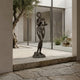 Large Classical Standing Nude Female Figure Bronze Sculpture by Giant Sculptures, 220cm, displayed on a stone threshold beside an olive tree in a courtyard.