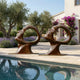 Pair of Giant Sculptures Large Contemporary Abstract Face Bronze Sculptures 150cm with circular voids, displayed poolside among lavender and olive trees.