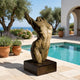 Large Contemporary Abstract Female Torso Bronze Sculpture by Giant Sculptures on a dark plinth beside a pool, with olive trees and sea view behind.
