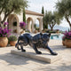 Large Contemporary Crouching Panther Bronze Sculpture by Giant Sculptures on a stone plinth beside a Mediterranean villa pool with olive trees and bougainvillea.