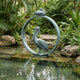 Giant Sculptures Large Contemporary Dual Pelican Bronze Sculpture with verdigris patina, set at a pond's edge among tropical foliage and stone steps.