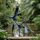 Large Contemporary Flying Cranes Bronze Sculpture by Giant Sculptures, 250cm flock lifting off from a tropical pond surrounded by palms and lush greenery.