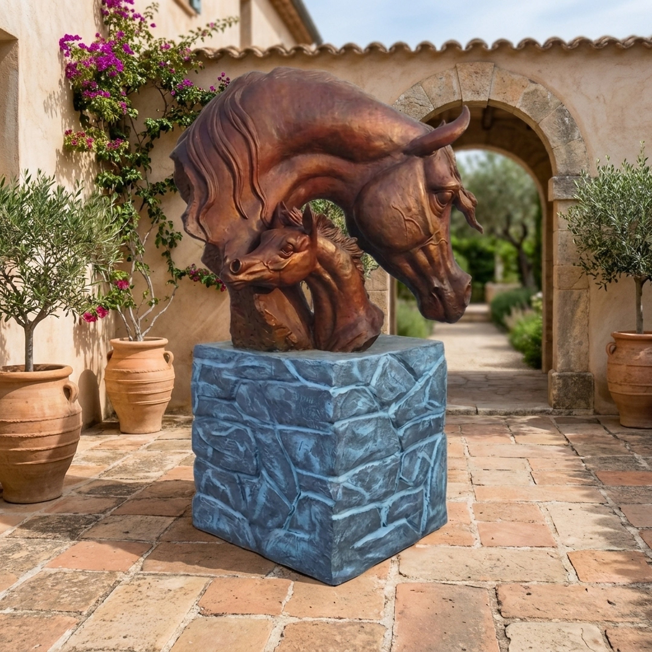 Large Contemporary Mare and Foal Bronze Sculpture by Giant Sculptures, 120cm, on stone-effect plinth in a Mediterranean courtyard with terracotta pots.