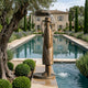 Large Contemporary Top Hat Figure Bronze Fountain by Giant Sculptures, 230cm gentleman in coat and hat with umbrella spouting water beside a garden pool.
