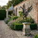 Large Contemporary Winged Horse Bronze Sculpture by Giant Sculptures on a carved stone plinth in a walled garden with lavender, roses, and a stone pavilion.