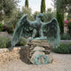 Large Heraldic Eagle Bronze Sculpture by Giant Sculptures with verdigris patina and outstretched wings, perched on stacked stone in a lavender-edged gravel garden.