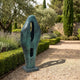 Large Modern Abstract Bronze Sculpture 120cm by Giant Sculptures with verdigris patina and two oval apertures, set on a gravel garden path beside lavender and hedging.