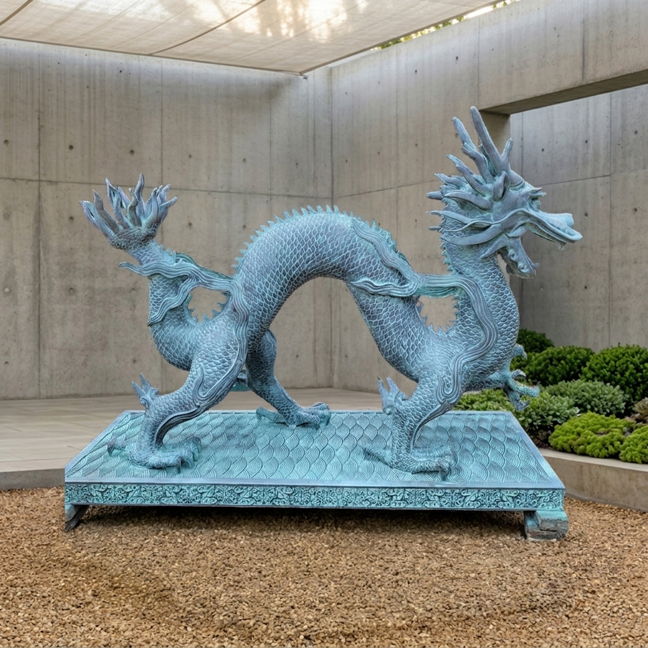 Large Traditional Chinese Dragon Bronze Sculpture by Giant Sculptures in turquoise verdigris, coiled S-curve pose on a decorated plinth in a concrete courtyard.