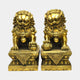 Large Traditional Chinese Guardian Lion Bronze Sculpture by Giant Sculptures, matched pair in polished gold tone on tiered Greek key plinths, plain background.