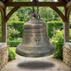 Large Traditional Church Bell Bronze Sculpture by Giant Sculptures, 120cm aged bronze bell with Latin inscription and cross relief, suspended in a timber garden shelter.