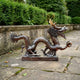 Large Traditional Coiling Chinese Dragon Bronze Sculpture by Giant Sculptures shown in profile on a stone patio, gripping a sphere with gold-toned horns.