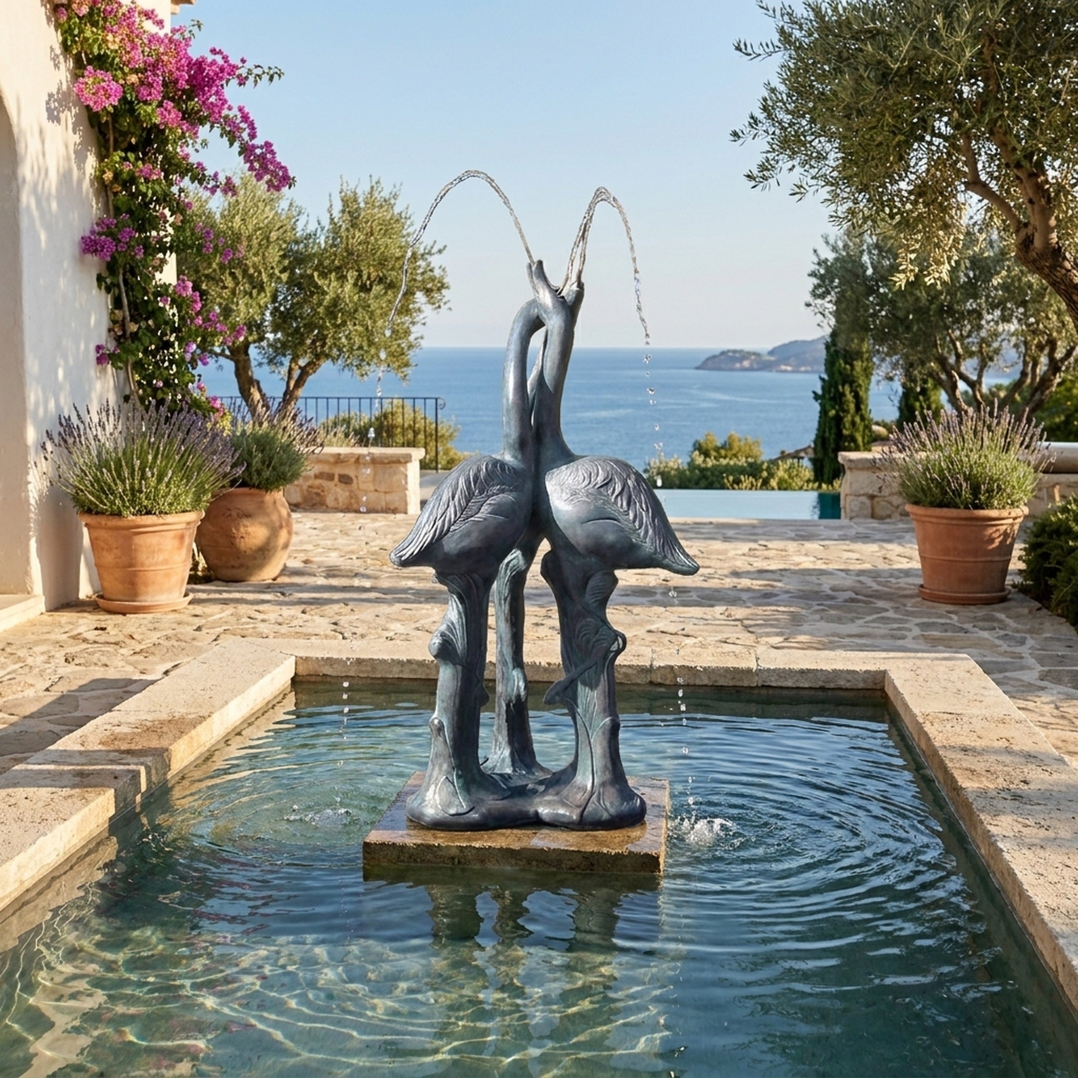 Large Traditional Crane Pair Bronze Fountain by Giant Sculptures with verdigris patina, set in a stone pool on a Mediterranean terrace overlooking the sea.
