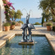 Large Traditional Crane Pair Bronze Fountain by Giant Sculptures with verdigris patina, set in a stone pool on a Mediterranean terrace overlooking the sea.