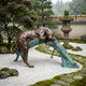 Giant Sculptures Large Traditional Crouching Leopard Bronze Sculpture draped over a verdigris log in a Japanese garden with raked gravel and stone lantern.